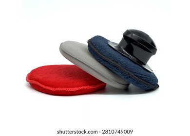 A set of car detailing applicators including foam pads and microfiber covers for wax and polish application