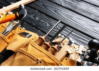 Set Of Carpenter's Tools And Saw Dust On Dark Wooden Background