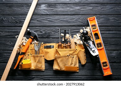 Set Of Carpenter's Tools And Saw Dust On Dark Wooden Background