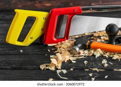 Set Of Carpenter's Tools And Saw Dust On Dark Wooden Background