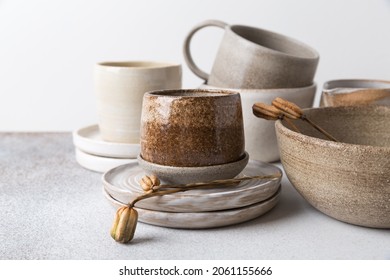 Set of ceramic tableware. Empty craft ceramic plates, bowls, and cups on a light background.