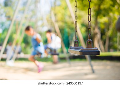Set of chain swings on modern kids playground, kids swinging on back - Shutterstock ID 243506137