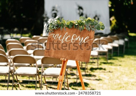 Set a charming mood at your outdoor wedding with a welcome sign and chairs for a beautiful ceremony