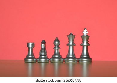 Set Of Chess Figures In A Row Isolated On A Red Background