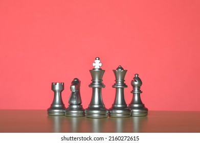 Set Of Chess Figures In A Row Isolated On A Red Background