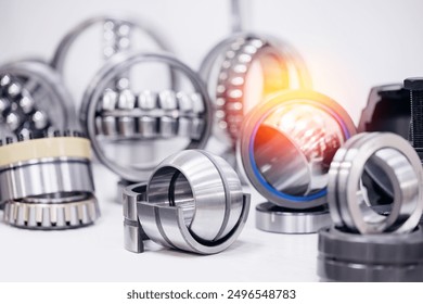 Set of chrome plated round deep roller ball and groove bearings on blur background. Products for heavy CNC equipment and mechanical engineering.