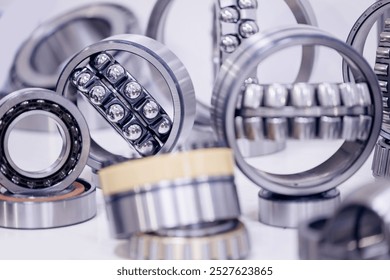 Set of chrome plated round deep roller ball and groove bearings on blur background. Products for heavy CNC equipment and mechanical engineering.