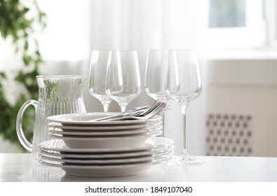 Set Of Clean Dishes, Cutlery And Glassware On Table Indoors