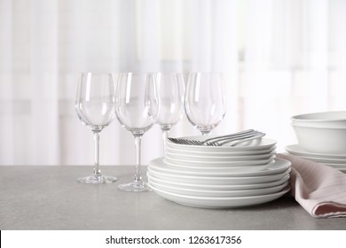 Set Of Clean Dishes On Table Against Blurred Background