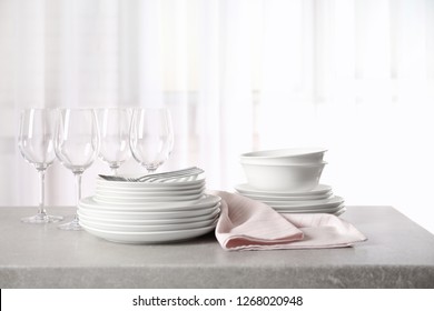 Set Of Clean Dishes On Table Against Blurred Background