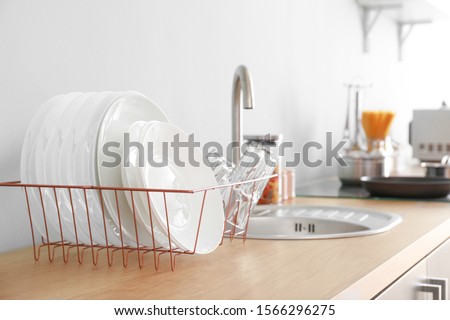 Set of clean dishware near kitchen sink