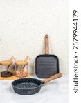 Set of clean kitchenware on white table against brick wall cookware utensils