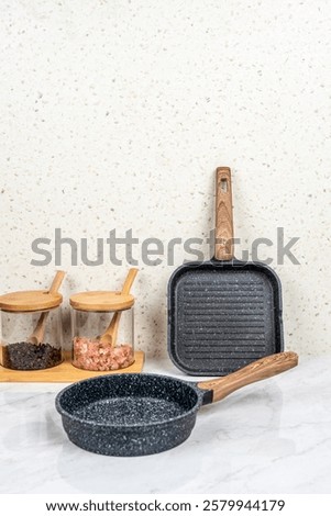Set of clean kitchenware on white table against brick wall cookware utensils