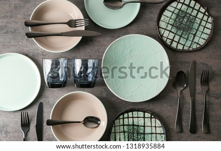 Set of clean tableware on grey background