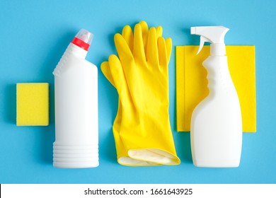 Set of cleaning supplies on blue background. Flat lay yellow rag and sponge, rubber gloves, cleaner spray bottle, detergent. House cleaning service and housekeeping concept - Powered by Shutterstock