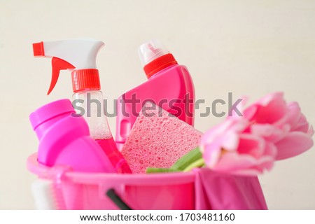 Set of cleaning supplies and spring flowers on white background, closeup