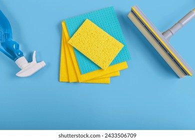 Set for cleaning windows on blue background. Concept of Housekeeping, professional clean service, housework kit supplies. Top view, flat lay with free copy space - Powered by Shutterstock