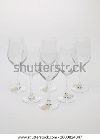 Set of clear glass stemware goblets isolated on white background.