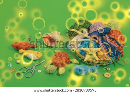Set of clew of thread for knitting. Crocheted different underwater animals, handmade marine hobby concept. Props and special craft tools on green background, copy space