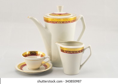 Set of coffee. White porcelain with gold maroon pattern. The coffee pot, milk jug and cup and saucer.