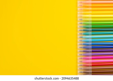 A set of colored markers.  Office and school supplies. Flat lay composition with markers and space for text on color background. Colored markers isolated on yellow background.