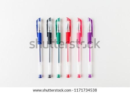 A set colored pens on a white background