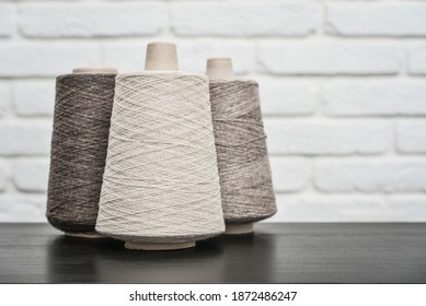 Set of colored yarn for knitting on cone on light background,  with copy space