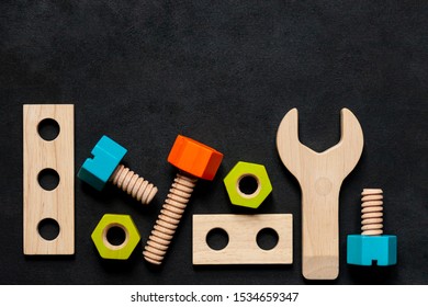 Set of colorful children's wooden toys. Construction kit with nuts and screws on dark black background. Interesting and fun game for boys and adults - Powered by Shutterstock