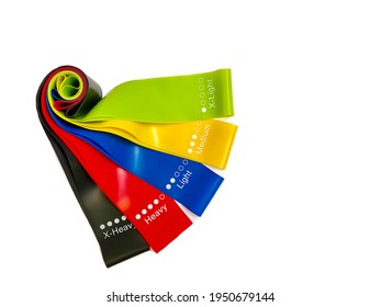 Set of colorful latex rubber bands for fitness on a white background.  Sports concept.  Home fitness workout trend.  Top view, flat lay, copy space, isolate.