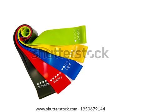 Set of colorful latex rubber bands for fitness on a white background.  Sports concept.  Home fitness workout trend.  Top view, flat lay, copy space, isolate.