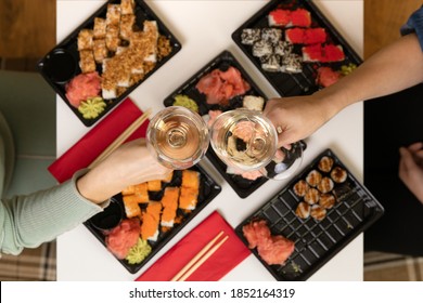 A Set Of Colorful Sushi Set On A White Table With Wine In A Cozy Room.