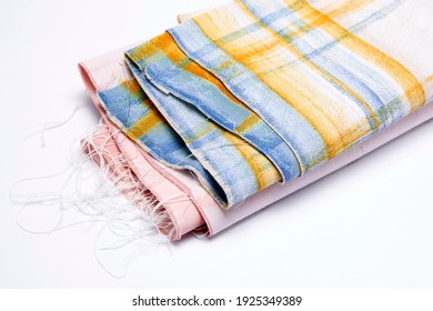 Set Of Colourful Tattered Fabric Threads, Rolled Up, With Pink, Blue And Yellow Line Pattern, On White Background