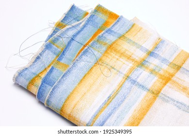 Set Of Colourful Tattered Fabric Threads, Rolled Up, With Blue And Yellow Line Pattern, On White Background