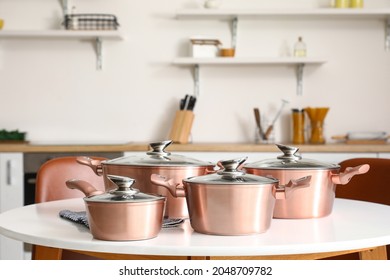 Set of copper cooking pots on table in kitchen - Shutterstock ID 2048709782