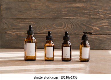 Set of cosmetic dark amber glass bottles on wooden background. Closeup, copyspace. Beauty blogging, salon treatment concept, minimalism brand packaging mock up