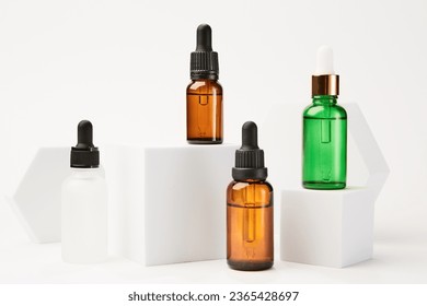 Set of cosmetic dropper bottles mockups near white shapes. - Shutterstock ID 2365428697