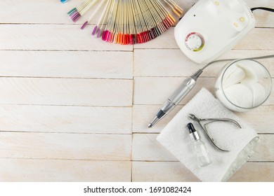 A set of cosmetic tools for manicure and pedicure on a blue background. Fraser, cotton pads, on a white towel there is oil for hands and cuticles, next to there is a palette of colors of gellaks on