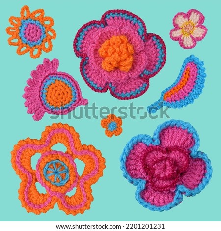  
A set of crocheted orange, pink, and blue elements isolated on a blue background.
