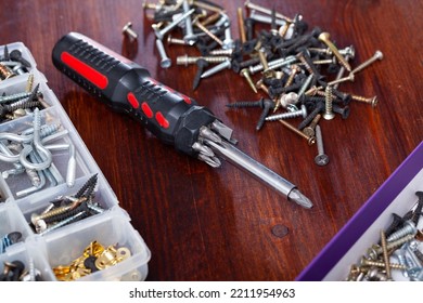 Set of crosshead screwdriver with tip set and fastening devices on wooden background