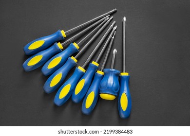 Set of crosshead screwdrivers with blue handles on black background