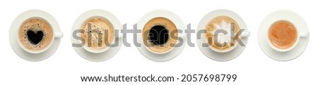 Set with cups of tasty aromatic coffee on white background, top view. Banner design