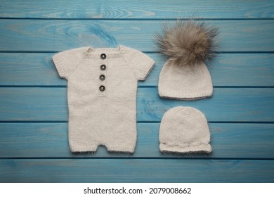 Set Of Cute Baby Knitwear For Photoshoot On Light Blue Wooden Background, Flat Lay