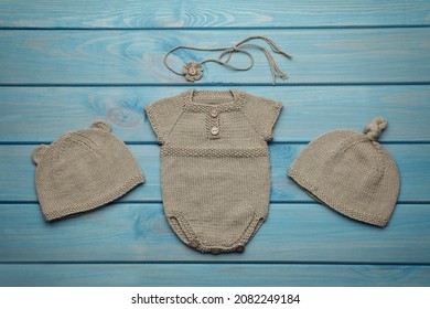 Set Of Cute Baby Knitwear For Photoshoot On Light Blue Wooden Background, Flat Lay