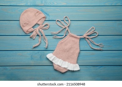 Set Of Cute Baby Knitwear For Photoshoot On Light Blue Wooden Background, Flat Lay