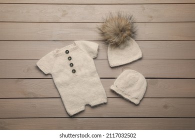 Set Of Cute Baby Knitwear For Photoshoot On Wooden Background, Flat Lay