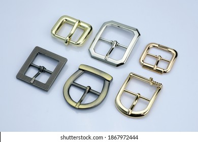 Set of decorative buckles made of metal. Curly metal buckles top view on a white background. Accessories for sewing clothes.