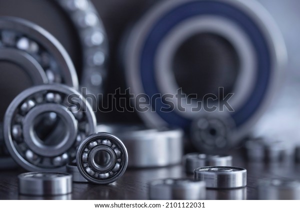 Set of deep groove\
ball and roller bearings on a gray background with soft focus.\
Axial chrome plated round bearings for heavy equipment and\
mechanical engineering\
close-up.