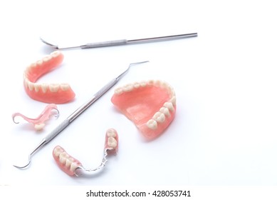 Set of dentures and dental tools on white background