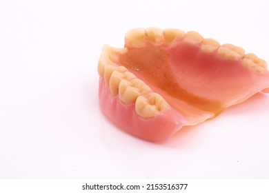 A Set Of Dentures And False Teeth Isolated On A White Background