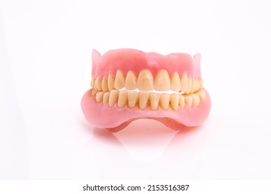 A Set Of Dentures And False Teeth Isolated On A White Background